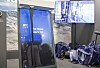Messestand med en blå Mark IV-presentasjon, skjermer og utstyr i bakgrunnen.
