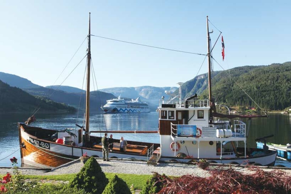 “Inne blant fjorder og snekledte fjell ligger Hardanger så skjønn”. Her med krigsveteranen M/K “Andholmen” og det tyske cruiseskipet “AIDAaurora”. Foto: Magne Åhjem