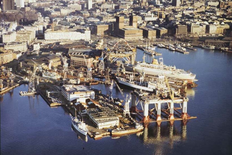 Fra Aker Mekaniske Verksted i Oslo på midten av 1970-tallet. Vi kan se cruiseskipet “Vistafjord” i flytedokken, to H-3 oljeplattformer, et sovjetisk lasteskip i den store tørrdokken, samt ytterst til venstre på Tjuvholmen ligger Kongeskipet “Norge”. Fotog